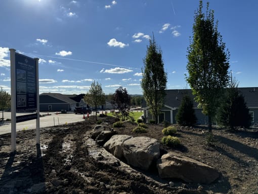 a landscaped area with rocks and trees in front of a building