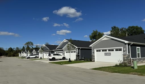 a row of houses with cars parked in front of them