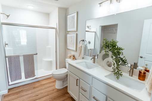 A white bathroom with a toilet, sink, and mirror.