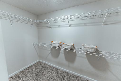 A white wall with a shelf and three bowls on it.