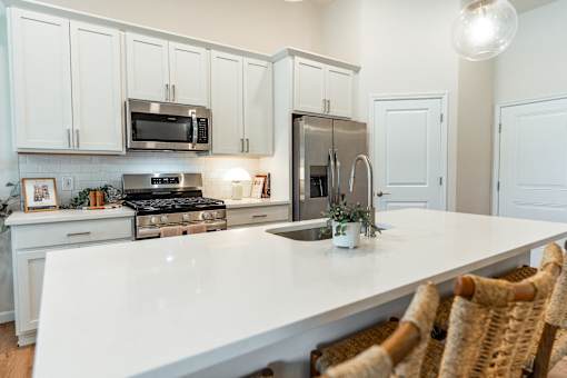 A kitchen with white cabinets and a white countertop.