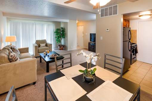 A living room with a couch, chair, and dining table.