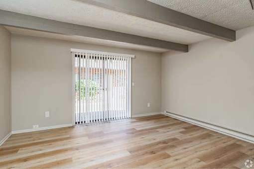 A room with wooden flooring and a sliding glass door.