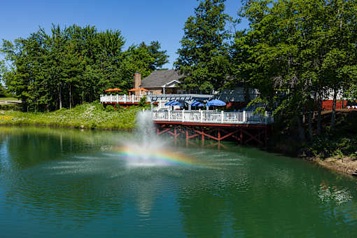 A fountain in the middle of a lake with a rainbow.