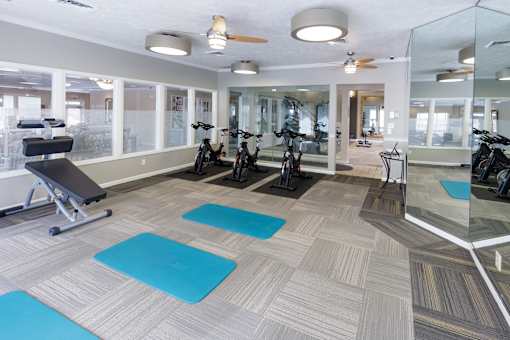 A gym with exercise equipment and mirrors.