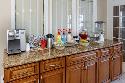 A kitchen counter with a coffee maker, a blender, and some baking ingredients.