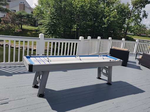 A table tennis table on a deck.