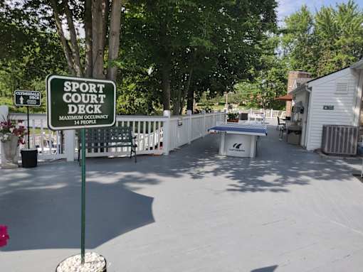 A sign for a sport court deck with a maximum occupancy of 14 people.
