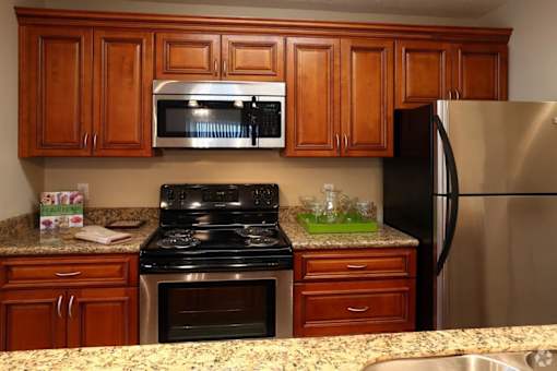 A kitchen with wooden cabinets and a granite countertop.