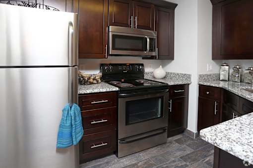 A kitchen with a stove, oven, refrigerator, and microwave.