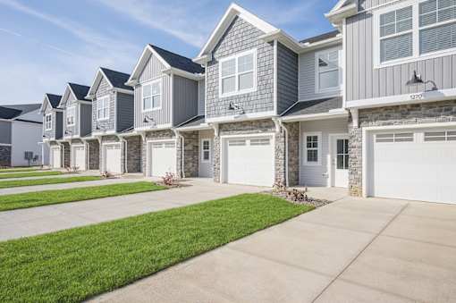 A row of houses with garages and driveways.