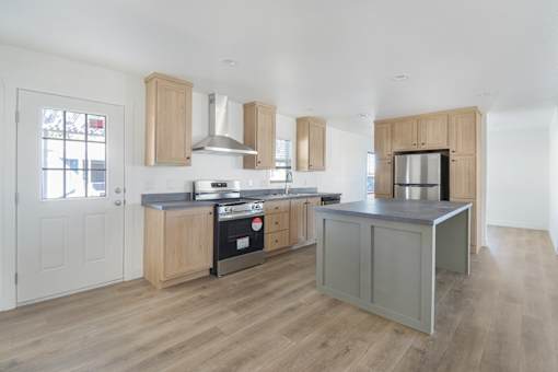 A kitchen with wooden cabinets and a grey island.