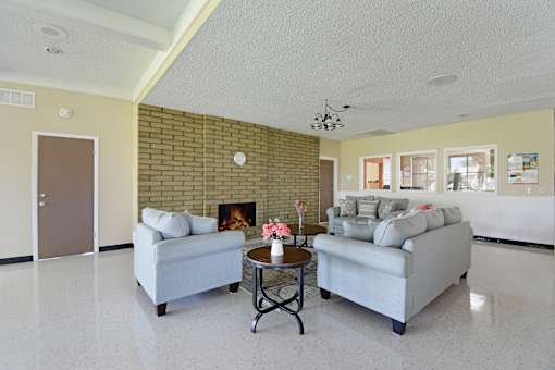 A living room with a fireplace and two couches.