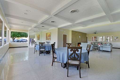 A dining room with tables and chairs.