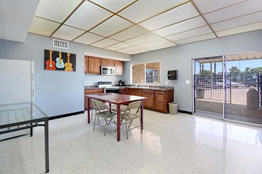A kitchen with a table and chairs.