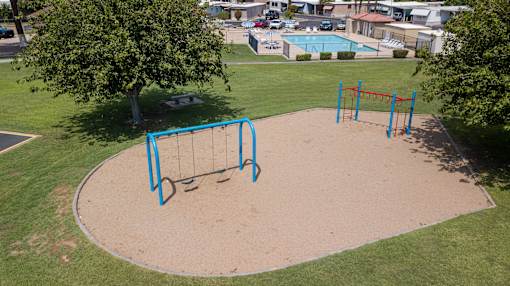 A playground with a blue swing set and a sandbox.