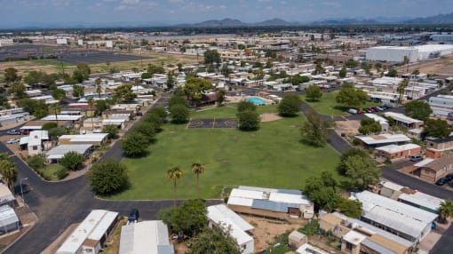 Bird's eye view of Belaire Manor, showing the large grass field, basketball court, playground equipment, and pool.
