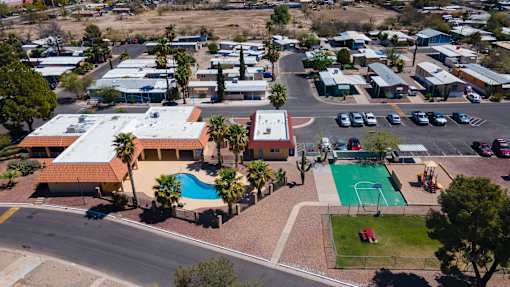 A view of a resort with a swimming pool and a basketball court.