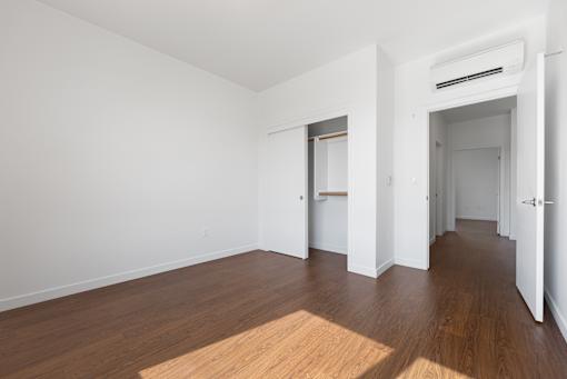 A room with wooden floors and white walls with two doors.