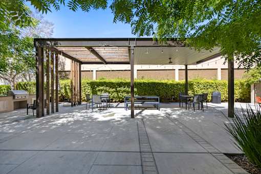 A patio with a table and chairs under a roof.