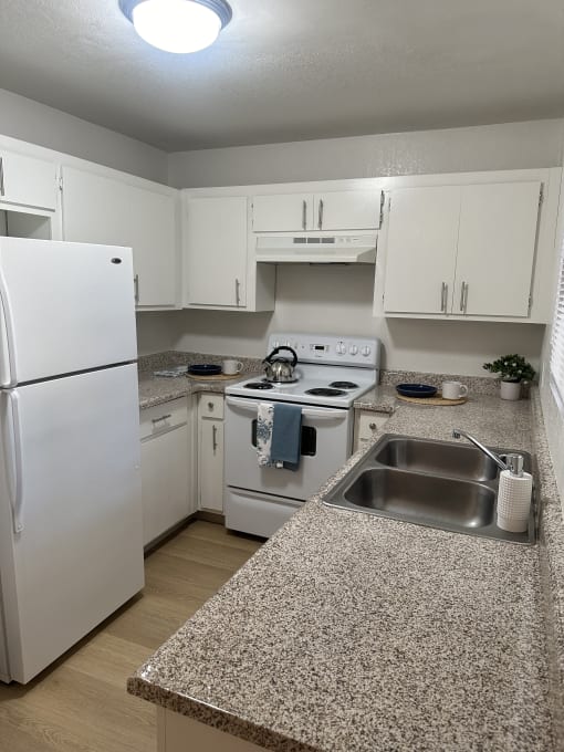 a small kitchen with a white counter top and a sink