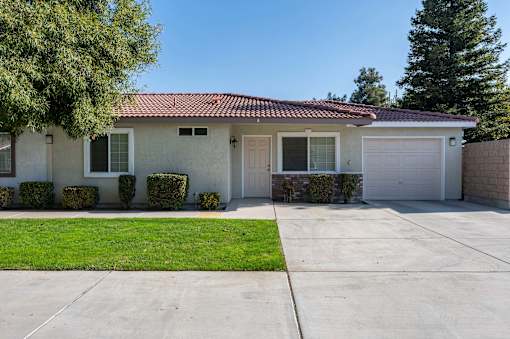 a white house with a white garage door and a lawn