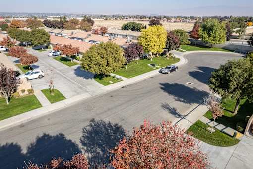 an aerial view of a parking lot with cars and trees