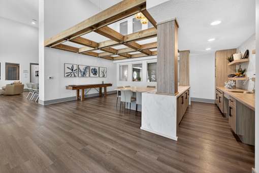 A kitchen with a wooden floor and a white wall.