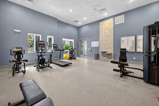 A gym with a variety of equipment including weights and cardio machines.