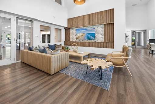 A living room with a wooden floor and a large painting on the wall.