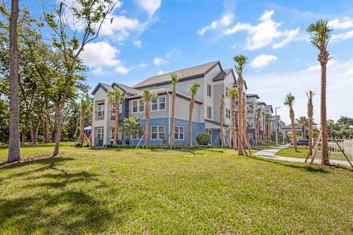 A row of houses with trees in front.