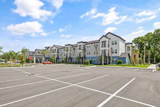 A parking lot with apartment buildings in the background.