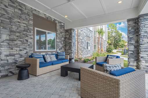 A patio with a couch, table and chairs.