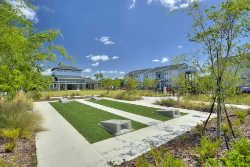 a park with benches and grass in front of a building