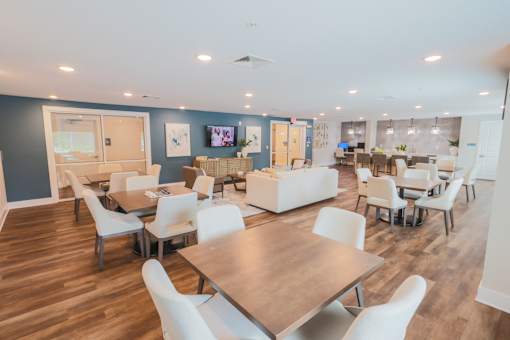 A spacious room with a long table surrounded by chairs.