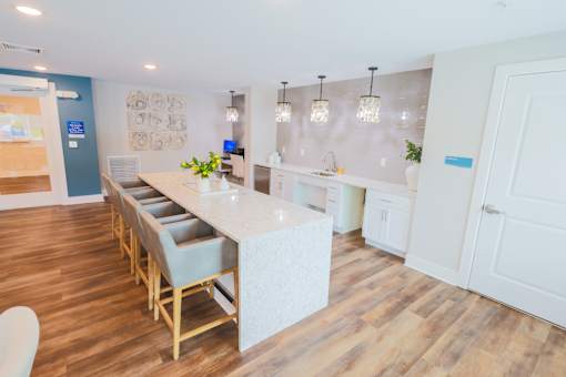 A kitchen with a long island and chairs.