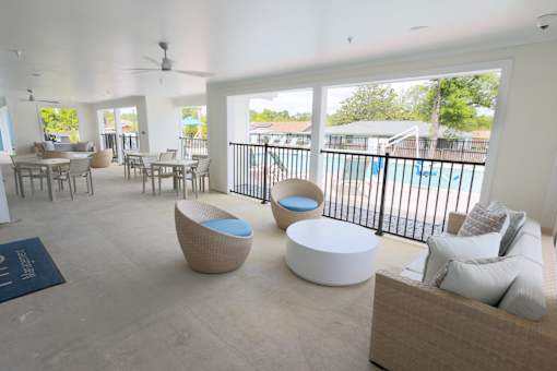 A spacious living room with a pool in the backyard.