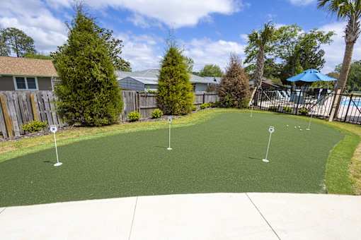 A backyard with a green lawn and a pool table.