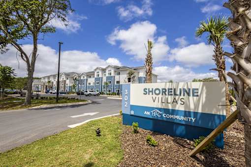A sign for Shoreline Villas is in front of a row of houses.
