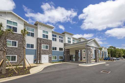 A modern building with a parking lot in front.
