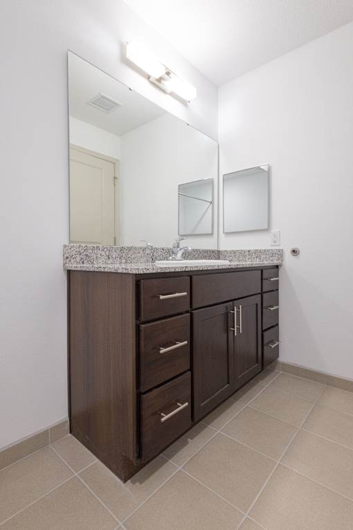 A bathroom vanity with a counter and a mirror above it.