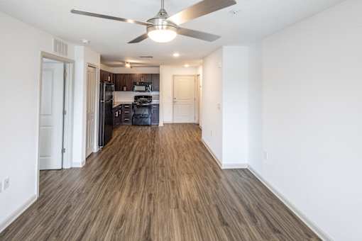 A room with a ceiling fan and wooden flooring.