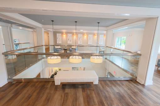 A modern living room with a glass table and a white bench.