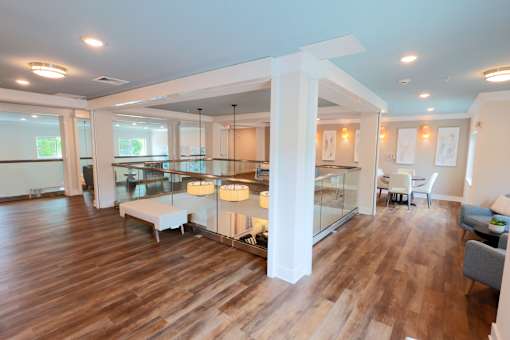 A modern open plan living and dining room with wooden floors and white furniture.