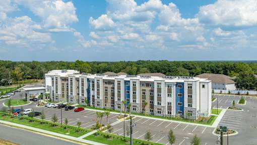 A large multi-story building with a parking lot in front.