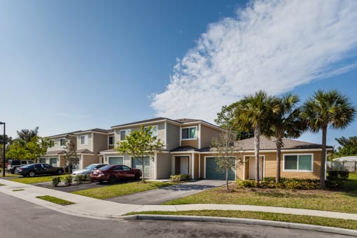 a row of houses with palm trees in front of them