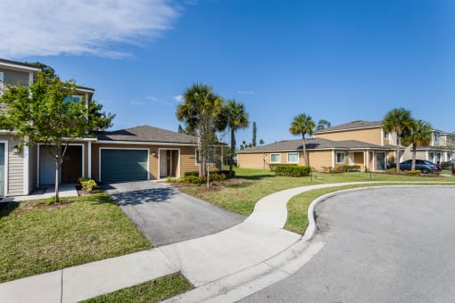 a street with houses and palm trees in the background