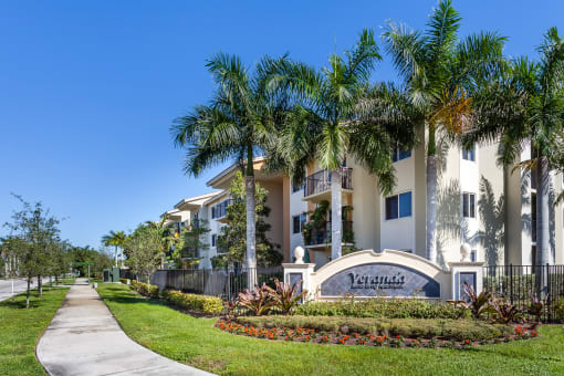 a large apartment building with palm trees in front of it