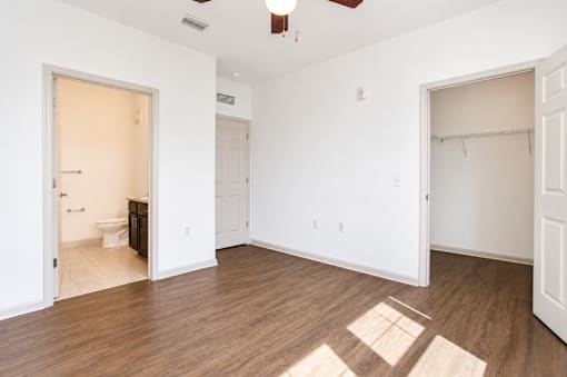 A room with a wood floor and a ceiling fan.