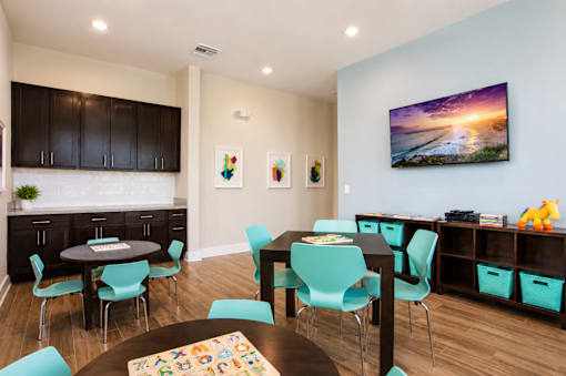 A dining room with a large table surrounded by chairs.